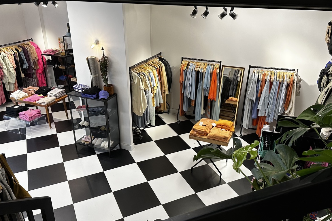 Damenmode-Etage bei HELLA & HERMANN — farbenfrohe faire Mode auf Schachbrettboden